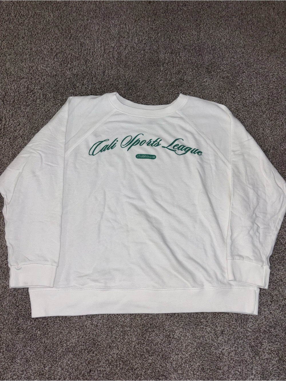 white crewneck with green writing